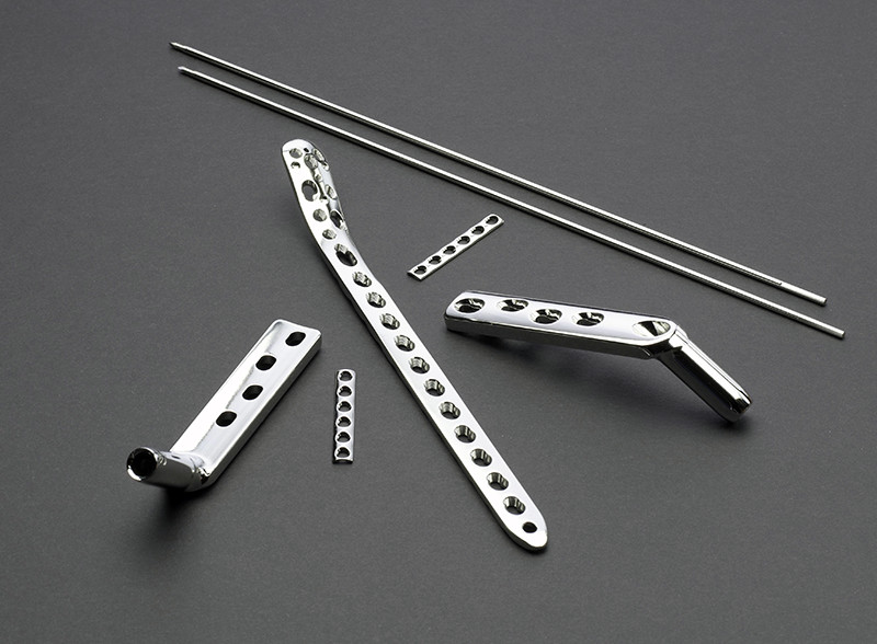 Five metal products whit holes and two two thin metal bars